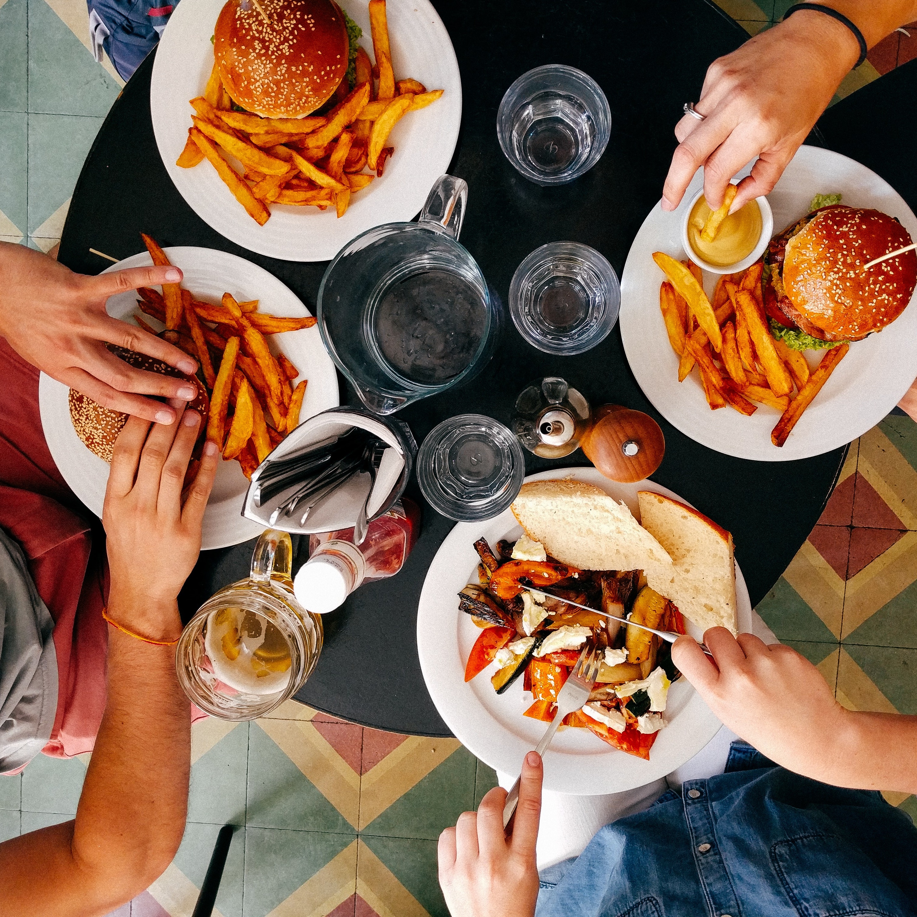 top down view of food on a table surrounded by 4 people