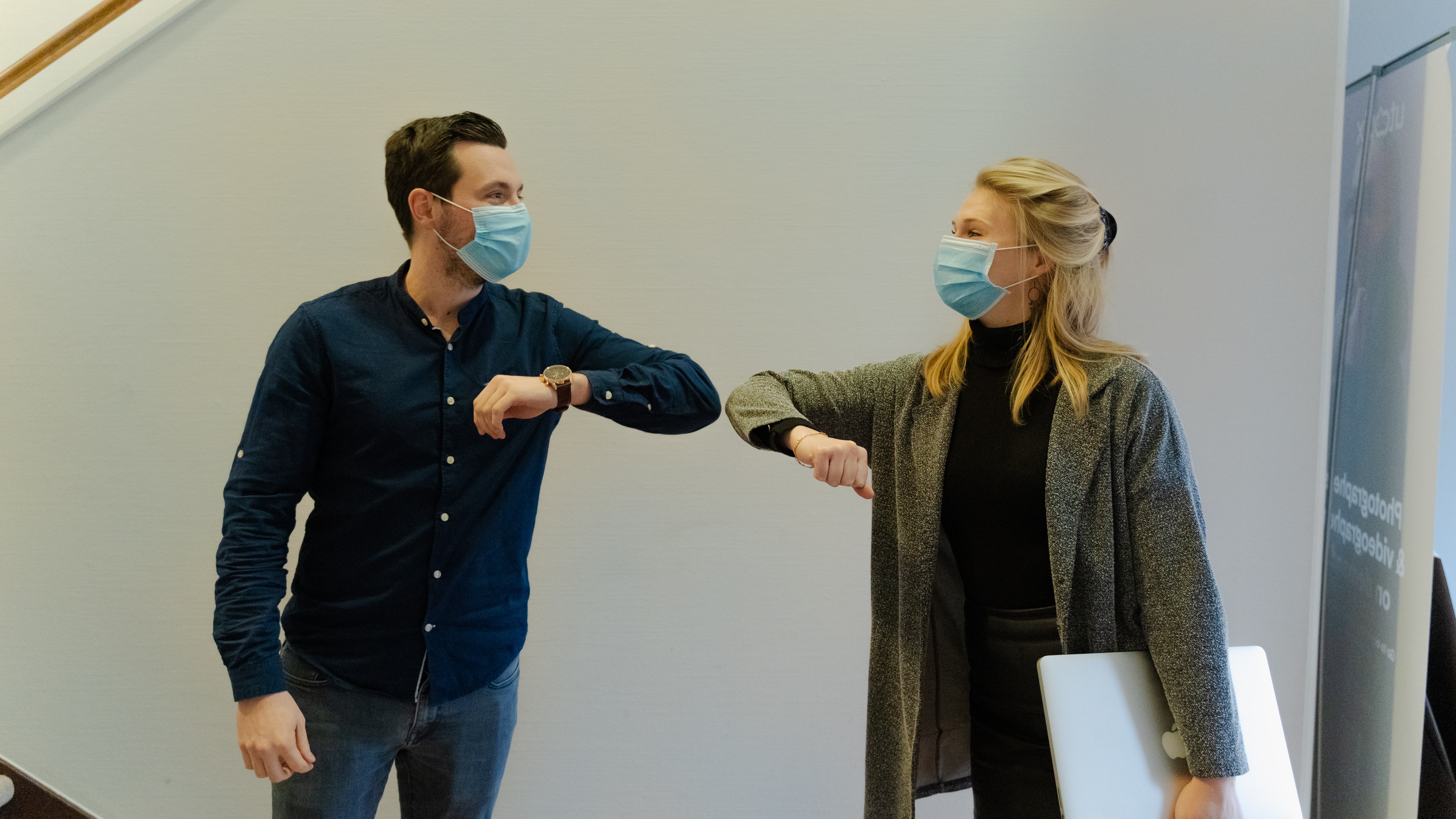two people bumping elbows instead of shaking hands to reduce the spread of germs