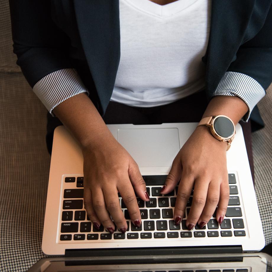 woman sitting and typing on laptop