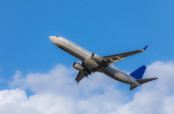 airplane takes off against a blue sky