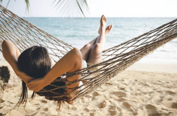 Woman relaxing in hammock on the beach